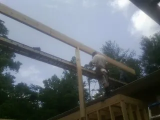 Carpenter setting a ridge beam over a new addition frame — Ice Dam Removal by Roofing Brothers in Camdenton
