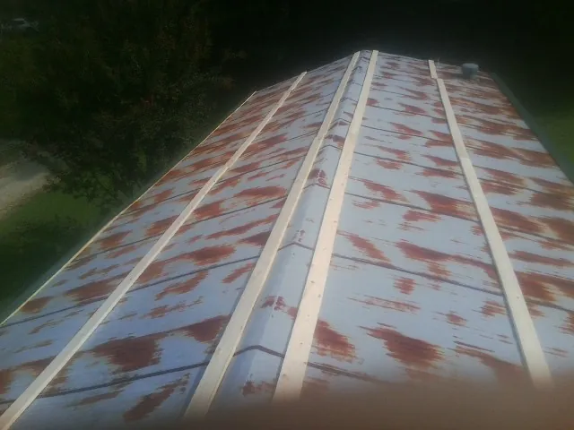 Rusted metal roof panels with new wood purlins before replacement — Storm Damage Roof Repair in Camdenton by Roofing Brothers