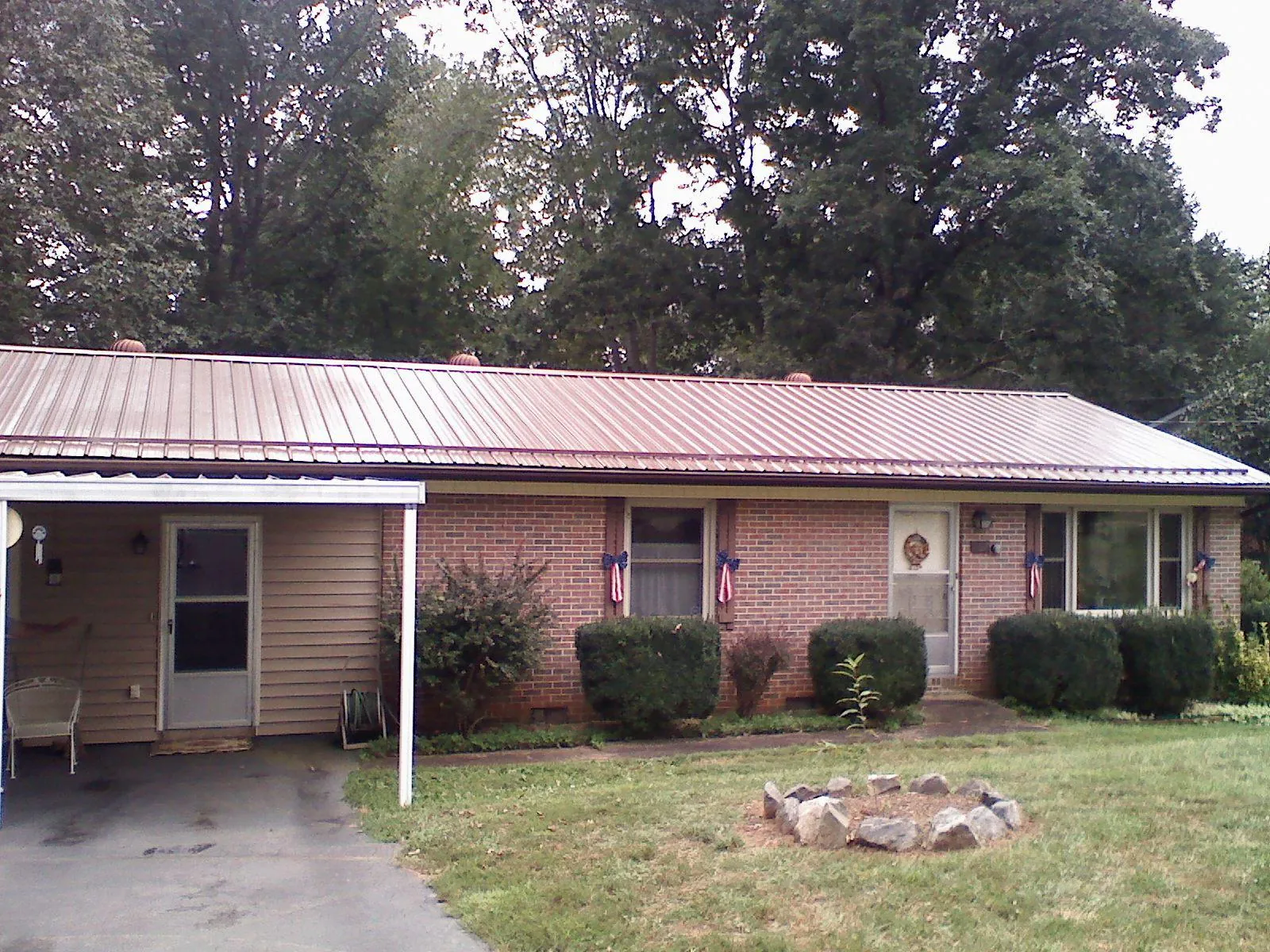 Bronze metal roof and carport on a brick ranch home — Roof Repair work by our crew in Camdenton