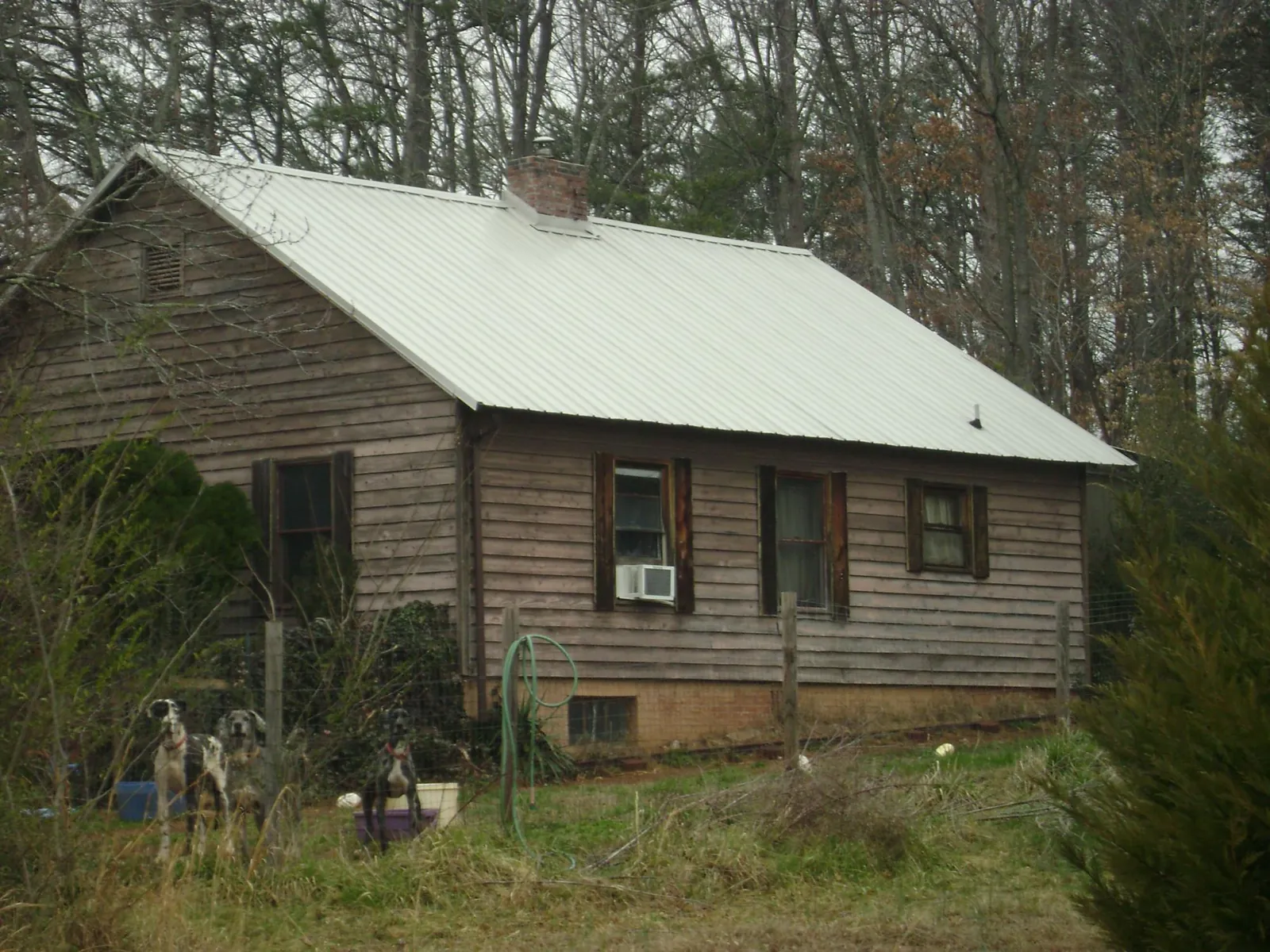 White metal roof on an old wood sided farmhouse, from a Asphalt Shingle Roof Repair job in Camdenton